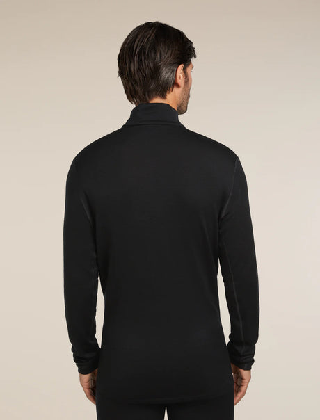Man wearing a black long-sleeve shirt against a beige background - Icebreaker Merino 260 Tech Long Sleeve Half Zip (Men's) - Black