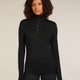 Woman wearing a black long-sleeve top with a quarter zip on a beige background - Icebreaker Merino 260 Tech Long Sleeve Half Zip Thermal Top (Women's) - Black