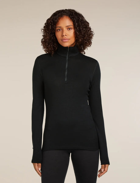 Woman wearing a black long-sleeve top with a quarter zip on a beige background - Icebreaker Merino 260 Tech Long Sleeve Half Zip Thermal Top (Women's) - Black
