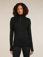 Woman wearing a black long-sleeve top with a quarter zip on a beige background - Icebreaker Merino 260 Tech Long Sleeve Half Zip Thermal Top (Women's) - Black
