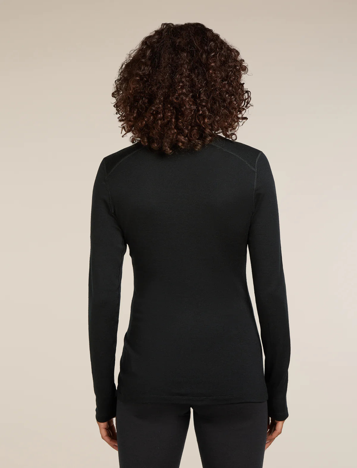 Person wearing a black long-sleeve top against a beige background - Icebreaker Merino 260 Tech Long Sleeve Half Zip Thermal Top (Women's) - Black