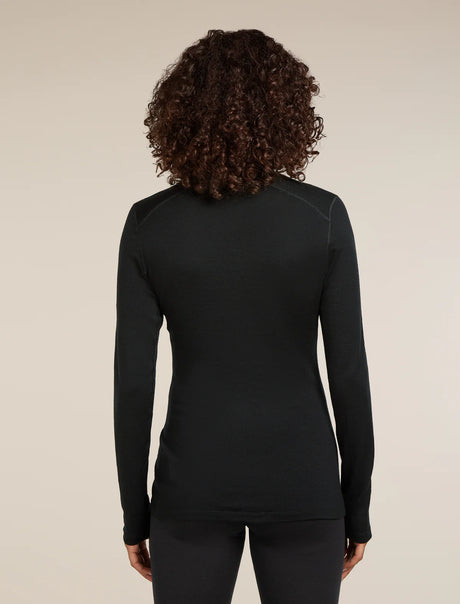 Person wearing a black long-sleeve top against a beige background - Icebreaker Merino 260 Tech Long Sleeve Half Zip Thermal Top (Women's) - Black