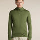 A man wearing an olive green full-zip hooded jacket with a vertical zip chest pocket, paired with light beige trousers, standing against a solid beige studio background. - Icebreaker Merino 260 Quantum Long Sleeve Zip Hoodie (Men's) - Sphagnum