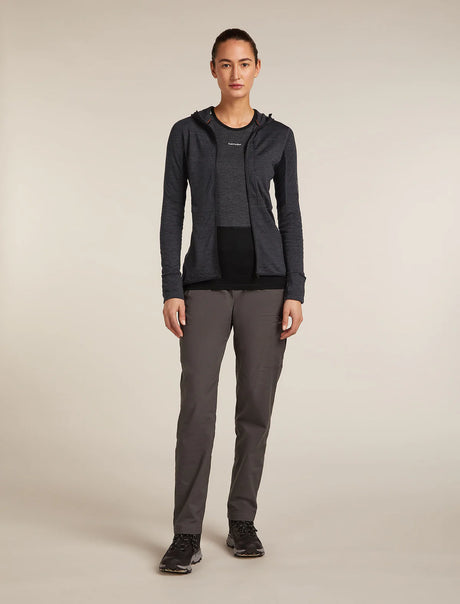 Person wearing a dark gray jacket and pants on a beige background - Icebreaker Merino Blend 200 Realfleece Descender Long Sleeve Zip Hoodie (Women's) - Jet Heather/Black