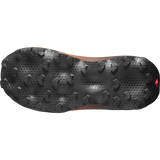The black treaded outsole of a trail running shoe, showing its aggressive grip pattern and textured design against a white background. - Salomon Ultra Glide 4 Shoes (Women's) - Huckleberry/Black/Red Orange