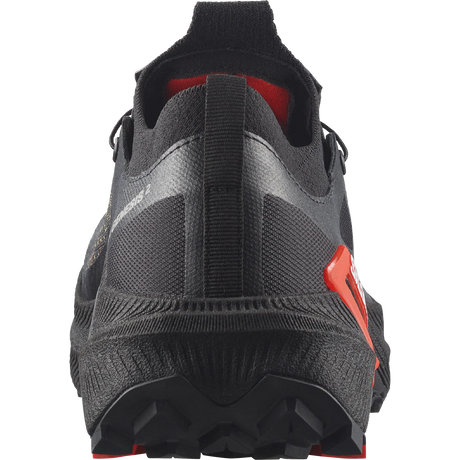 Close-up rear view of a black athletic shoe with red accents and a textured sole, shown on a white background. - Salomon S/LAB Genesis 2 Shoes (Unisex) - Black/Black/Fiery Red
