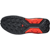The outsole of a Salomon trail running shoe, featuring a black treaded rubber base with bright orange-red accents and the Salomon brand name embossed on the heel. - Salomon S/LAB Genesis 2 Shoes (Unisex) - Black/Black/Fiery Red