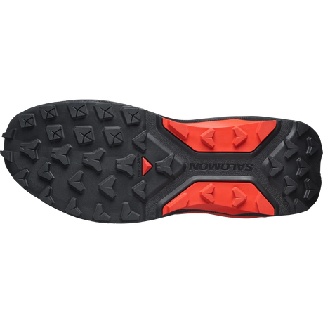 The outsole of a Salomon trail running shoe, featuring a black treaded rubber base with bright orange-red accents and the Salomon brand name embossed on the heel. - Salomon S/LAB Genesis 2 Shoes (Unisex) - Black/Black/Fiery Red
