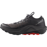 A black Salomon Black Genesis 2 trail running shoe with subtle orange stitching on the upper and a bright red outsole accent, shown in a side profile on a white background. - Salomon S/LAB Genesis 2 Shoes (Unisex) - Black/Black/Fiery Red