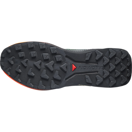 The bottom sole of a Salomon trail running shoe, showing a black textured tread pattern with a small red Salomon logo and a hint of orange on the heel edge, set against a plain white background. - Salomon Genesis 2 Shoes (Men's) - Urban Chic/Black/Lime Cream