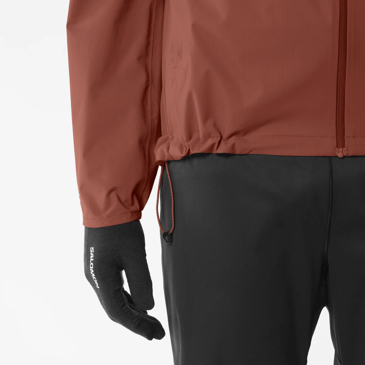 Brown jacket and black pants with a glove on a light gray background - Salomon Bonatti Waterproof Jacket (Men's) - Burnt Umber