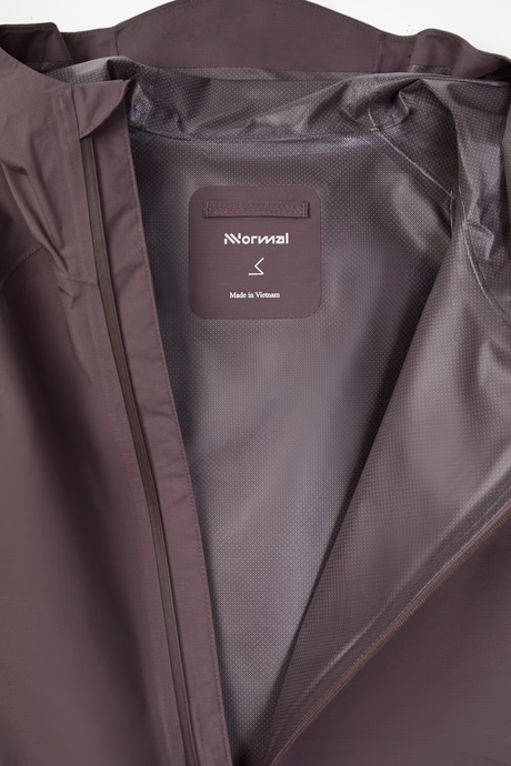 Close-up of the interior collar and lining of a dark brown jacket, showing a sewn-in label that reads 'Normal' and 'Made in Vietnam'. - NNormal Trail Rain Jacket 02 (Men's) - Purple