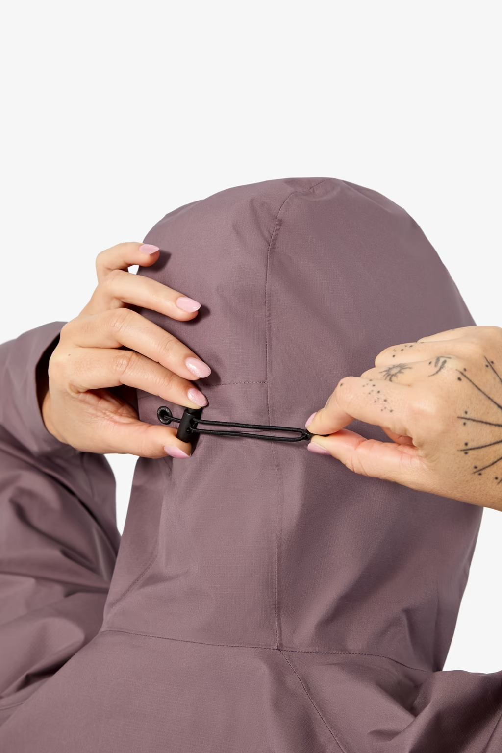 Person adjusting the hood of a purple raincoat on a white background - NNormal Trail Rain Jacket 02 (Women's) - Purple