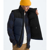 Person wearing a black and blue puffer jacket with a yellow beanie on a white background - The North Face 1996 Retro Nuptse Vest (Men's) - Summit Navy/TNF Black-Recycled Down