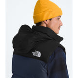 Person wearing a black The North Face jacket and yellow beanie on a white background - The North Face 1996 Retro Nuptse Vest (Men's) - Summit Navy/TNF Black-Recycled Down