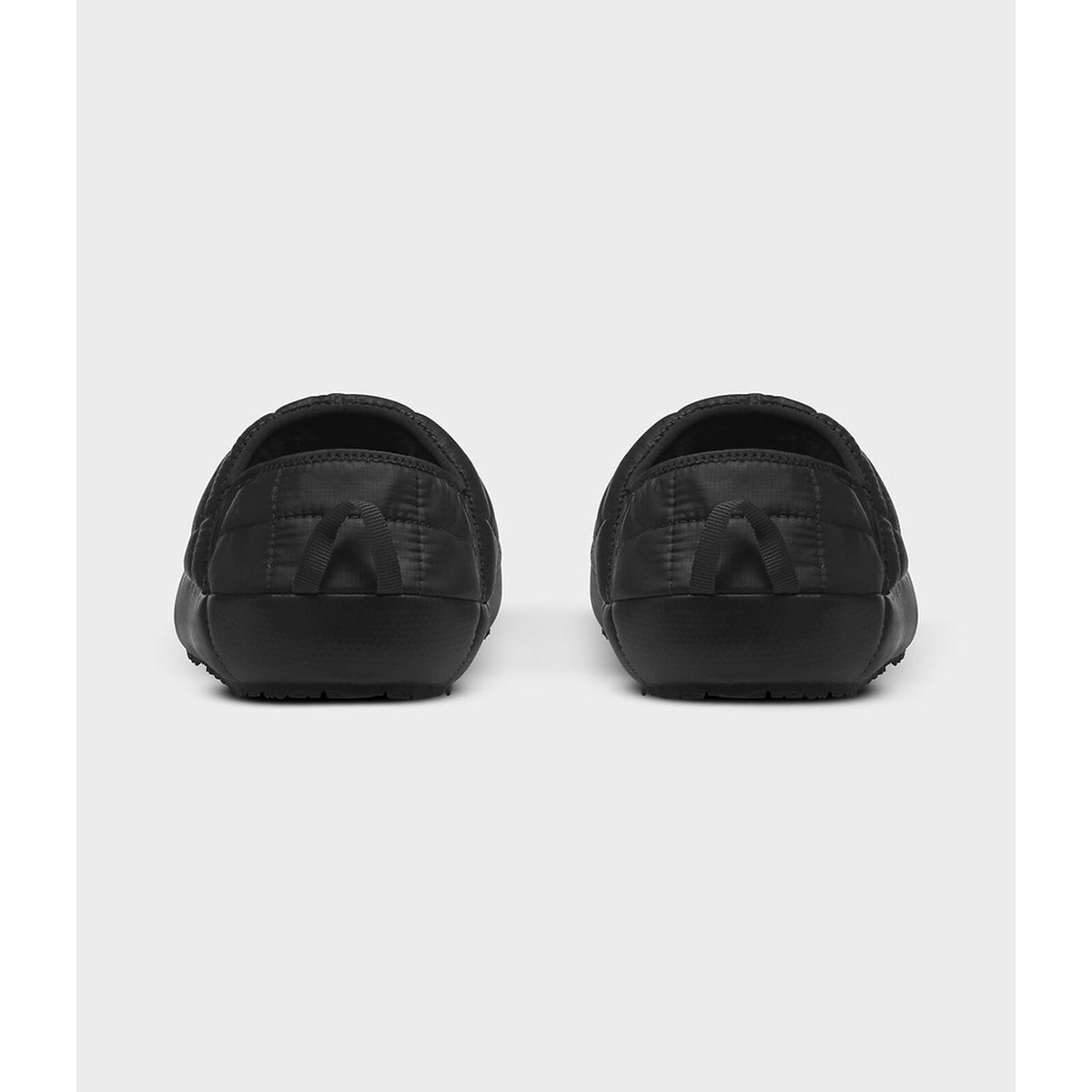 A pair of black slip-on clogs shown from the back, featuring a quilted pattern on the upper and a thick black sole, set against a light gray background. - The North Face ThermoBall Traction V Mules (Men's) - TNF Black/TNF White
