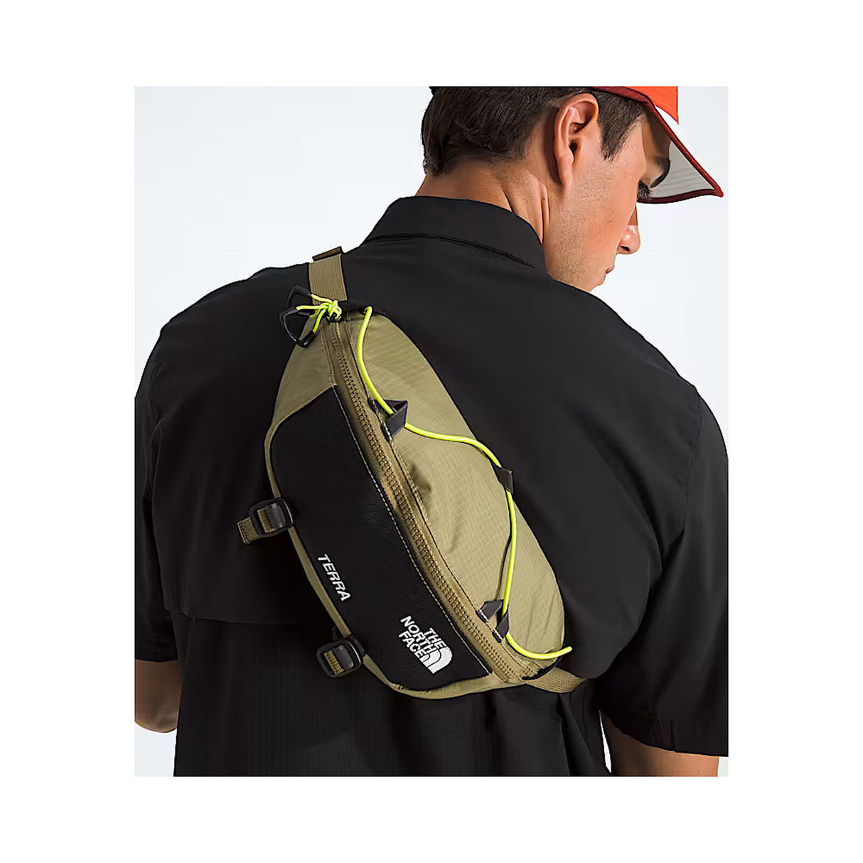 Person wearing a green and black sling bag with 'The North Face' logo on a white background - The North Face Terra Lumbar 6L - Cedar/TNF Black/Fizz Lime