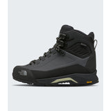 A high-top hiking boot by The North Face in black and dark gray, featuring a lace-up front, protective toe cap, and Vibram sole, shown against a light gray background. - The North Face Verto Alpine Mid GORE-TEX Boots (Women's) - Anthracite Grey/Lemon Mist
