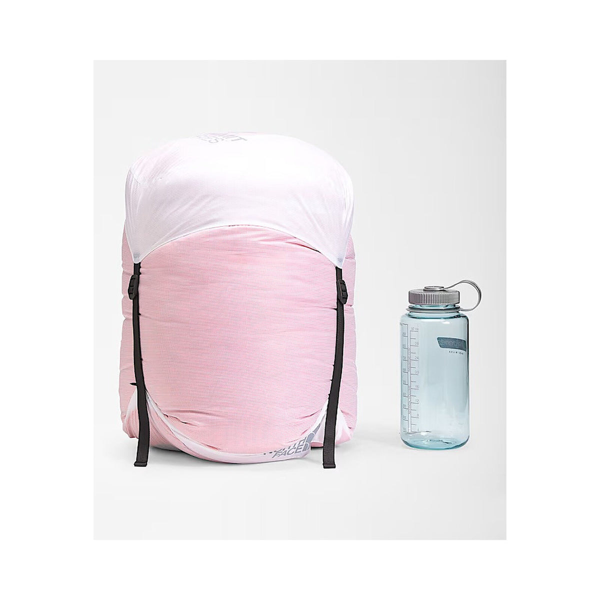 A light pink backpack cover fitted over a backpack, shown next to a translucent blue water bottle on a light gray background. - The North Face Inferno Sleeping Bag - 20F / -29C
