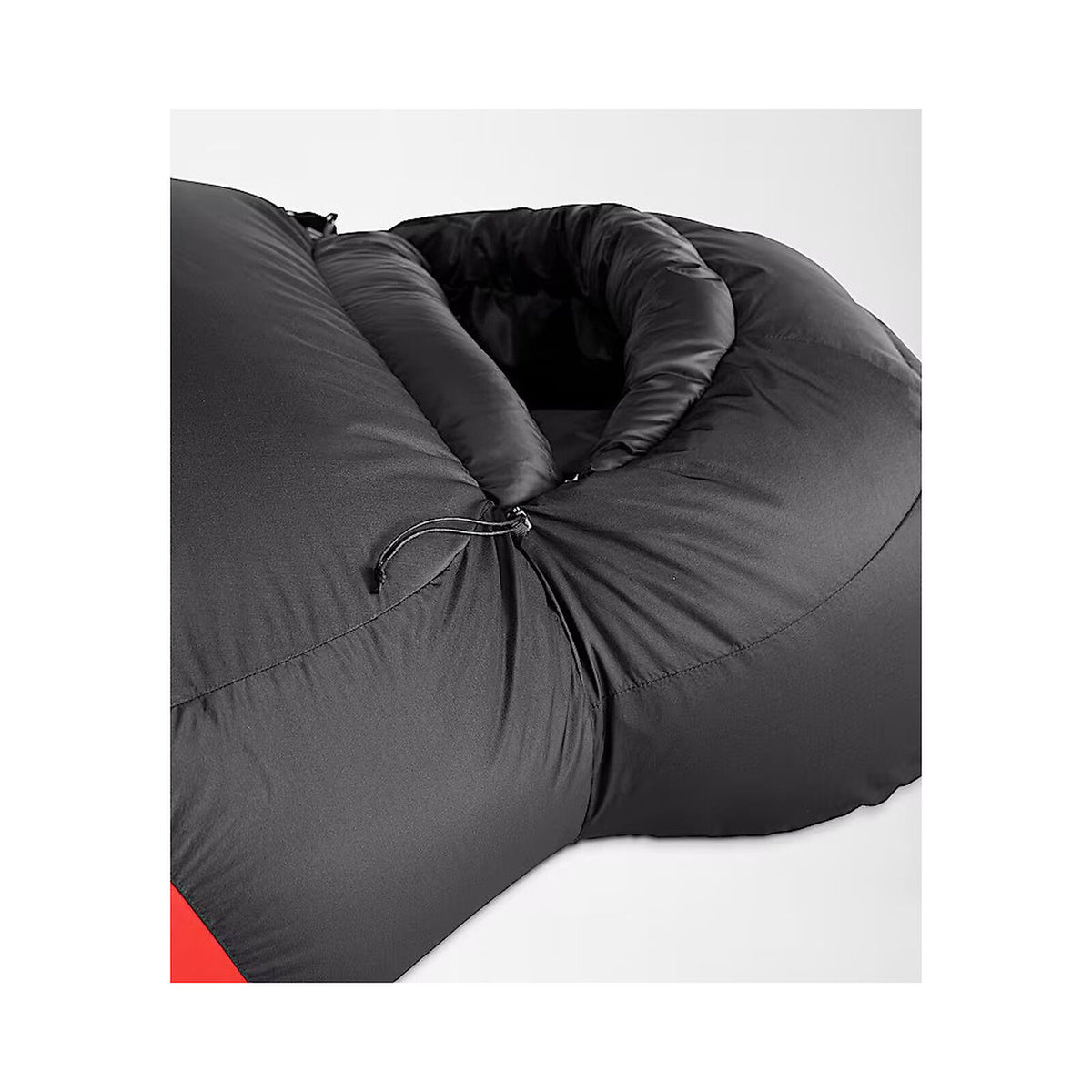 Close-up of a black puffy sleeping bag or padded pouch with a drawstring closure, photographed on a light gray background. - The North Face Inferno Sleeping Bag - 20F / -29C