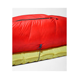 A bright red sleeping bag or padded sleeping pad shown folded and stacked on top of a yellow padded item, photographed on a clean light gray studio background. - The North Face Inferno Sleeping Bag - 20F / -29C