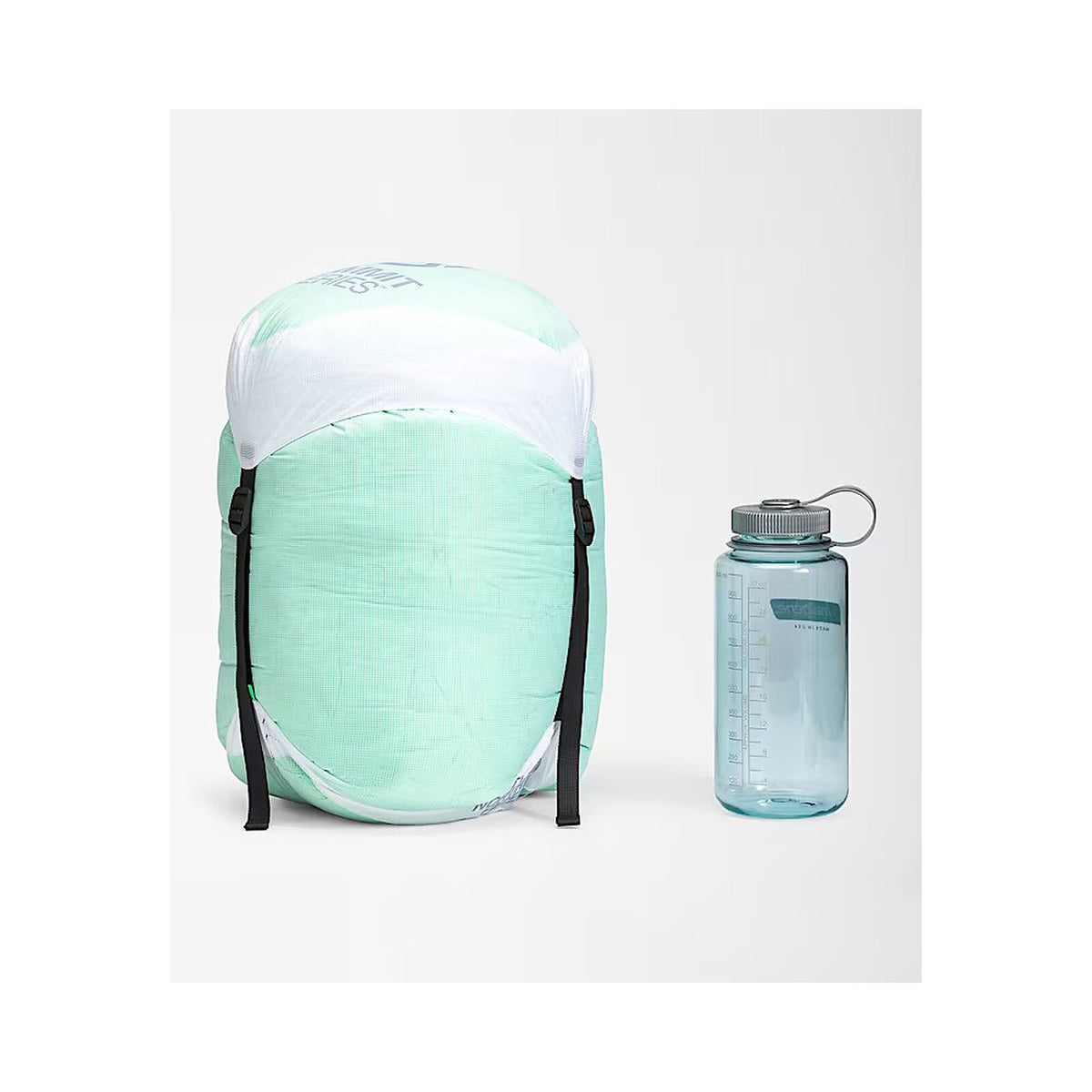 A mint green and white backpack shown next to a translucent blue water bottle with a gray cap, set against a plain light gray background. - The North Face Inferno Sleeping Bag - 0F / -18C