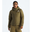 Person wearing a green puffer jacket with a brand logo on a white background - The North Face Terra Peak Hooded Jacket (Women's) - Cedar
