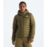 Person wearing a green puffer jacket with a brand logo on a white background - The North Face Terra Peak Hooded Jacket (Women's) - Cedar