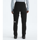 Rear view of a person wearing black The North Face pants with a light blue long-sleeve shirt, standing against a light gray studio background. - The North Face Summit Summit Series Off Width Pants (Women's) - TNF Black