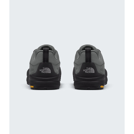 A pair of The North Face low-top sneakers shown from the back, featuring a dark gray and black colorway with a small orange logo accent on the outsole. - The North Face Verto Approach Shoes (Unisex) - Smoked Pearl/TNF Black