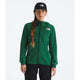 A woman wearing a green The North Face zip-up hooded jacket, a black The North Face cap, and black pants, standing against a light gray studio background. - The North Face Summit Series Off Width Jacket (Women's) - Evergreen