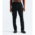 A model wearing black athletic jogger pants with a small white logo on the left thigh, paired with black shoes, shown from the waist down on a white studio background. - The North Face Summit FUTUREFLEECE Pants (Men's) - TNF Black