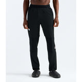 A model wearing black athletic jogger pants with a small white logo on the left thigh, paired with black shoes, shown from the waist down on a white studio background. - The North Face Summit FUTUREFLEECE Pants (Men's) - TNF Black