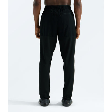 Black athletic pants with a drawstring waist, shown from the back on a model against a light gray studio background. - The North Face Summit FUTUREFLEECE Pants (Men's) - TNF Black