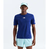 A male model wearing a royal blue short-sleeve athletic t-shirt by The North Face, paired with light blue shorts and a matching light blue cap, set against a plain light gray studio background. - The North Face Summit High Trail Short Sleeve-Graphic (Men's) - Bold Blue