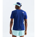 A man wearing a royal blue short-sleeve athletic t-shirt from the back, paired with light blue shorts and a matching light blue and navy cap, against a plain white background. - The North Face Summit High Trail Short Sleeve-Graphic (Men's) - Bold Blue