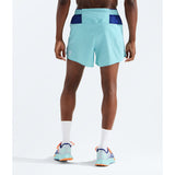 A person shown from the back wearing light aqua athletic shorts with dark blue side panels and waistband, white socks, and running shoes against a clean white studio background. - The North Face Summit Series Pacesetter 5" Run Shorts-Graphic (Men's) - Canal Blue
