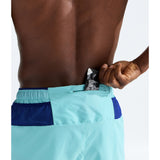 Close-up back view of a shirtless person wearing light aqua and navy athletic shorts, with a hand reaching into the back pocket area. - The North Face Summit Series Pacesetter 5" Run Shorts-Graphic (Men's) - Canal Blue