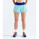 A model from the waist down wearing light blue athletic running shorts with a dark blue waistband, white crew socks, and blue running shoes with orange laces, set against a plain white studio background. - The North Face Summit Pacesetter Short-Graphic (Women's) - Canal Blue