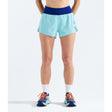 A model from the waist down wearing light blue athletic running shorts with a dark blue waistband, white crew socks, and blue running shoes with orange laces, set against a plain white studio background. - The North Face Summit Pacesetter Short-Graphic (Women's) - Canal Blue