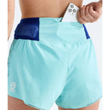 A close-up of a person wearing mint aqua running shorts with a dark blue waistband and a white phone tucked into the side pocket. The brand logo 'Ghost Racing' is visible on the lower left leg. - The North Face Summit Pacesetter Short-Graphic (Women's) - Canal Blue