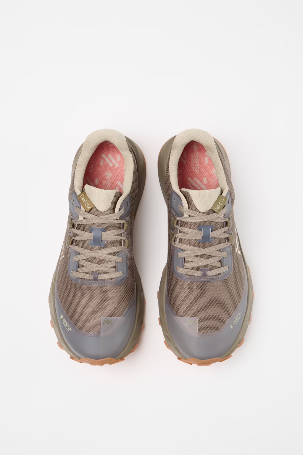 A pair of trail running shoes in a muted taupe and gray colorway, featuring a mesh upper, lace-up closure, and a pink interior lining, shown from a top-down view on a white background. - NNormal Cadí GORE-TEX Shoes (Men's) - Brown