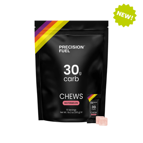 A black stand-up pouch of Precision Fuel 30g carb chews in Watermelon flavor, shown on a white background with a green 'NEW!' badge in the top right and a single pink chew visible at the bottom right. - Precision Fuel & Hydration 30 Chew - Watermelon - 15 Pack - Bag