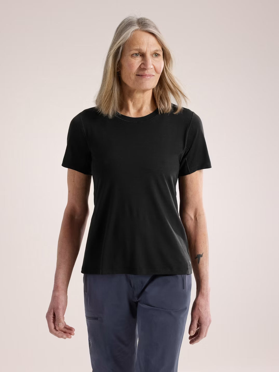 Woman wearing a black t-shirt and blue pants on a plain background - Arc'teryx Lana Merino Wool Crew Short-Sleeve T-Shirt (Women's) - Black