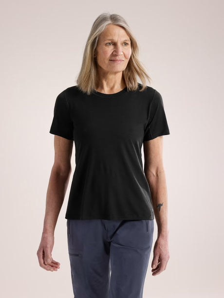Woman wearing a black t-shirt and blue pants on a plain background - Arc'teryx Lana Merino Wool Crew Short-Sleeve T-Shirt (Women's) - Black