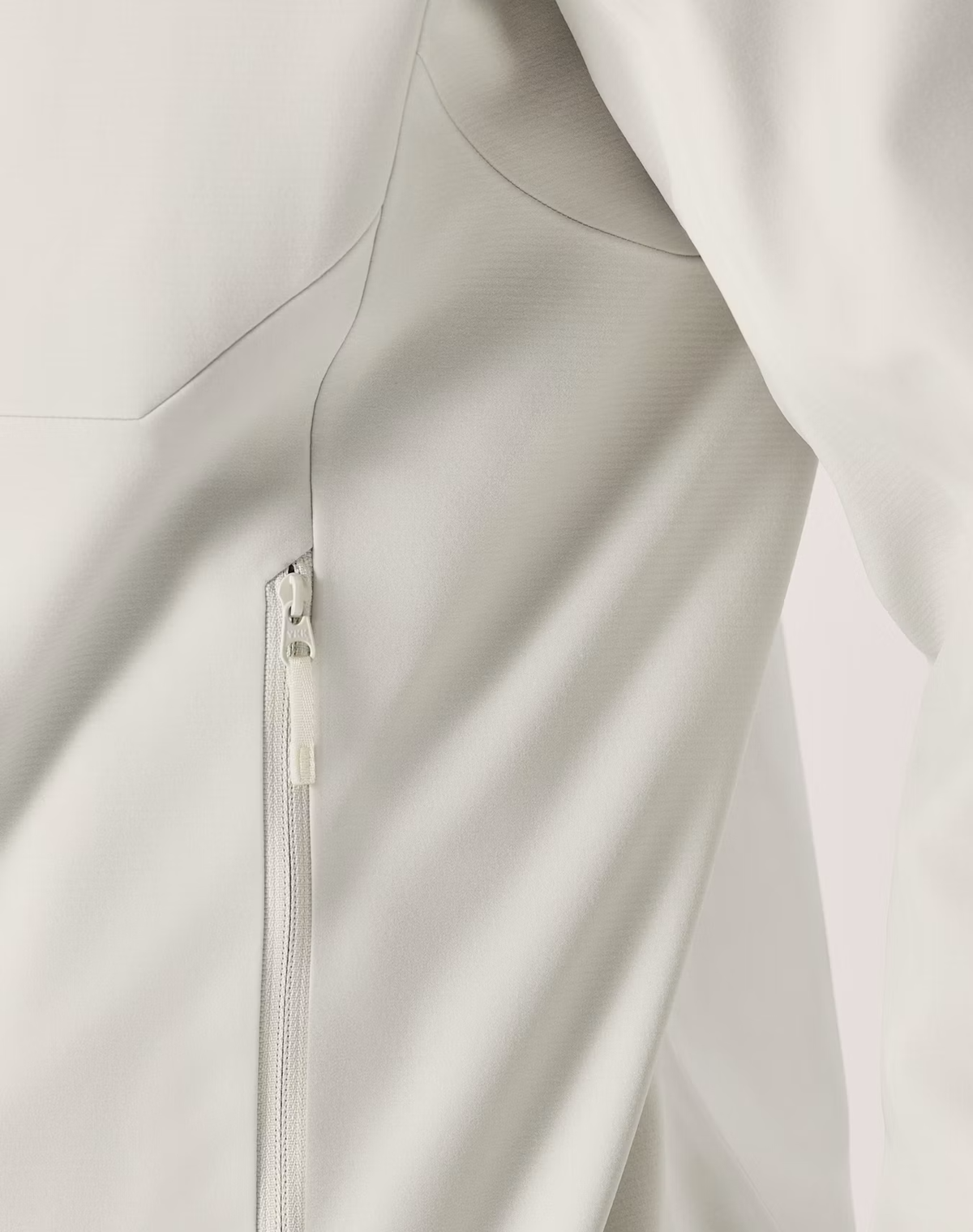Close-up of a light gray zippered jacket or outerwear garment, showing the fabric texture and zipper detail. - Arc'teryx Gamma MX Hoody (Men's) - Sea Salt
