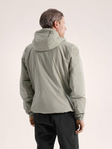 Person wearing a green jacket on a beige background - Arc'teryx Atom Hoody (Men's) - Habitat