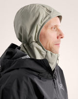 A man in profile wearing an Arc'teryx hooded jacket in a dark gray color, with the light gray hood up. The Arc'teryx logo is visible on the hood and chest. - Arc'teryx Atom Hoody (Men's) - Habitat