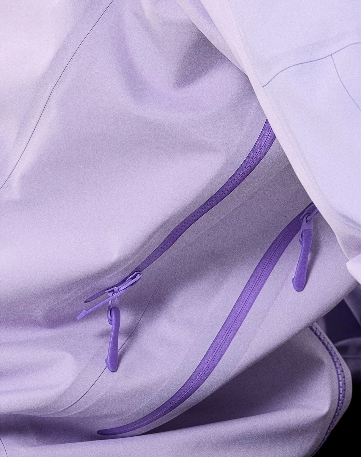 Close-up of a light lavender jacket with matching purple zipper pulls and a darker purple zipper track. - Arc'teryx Beta AR GORE-TEX Jacket (Women's) - Mallow