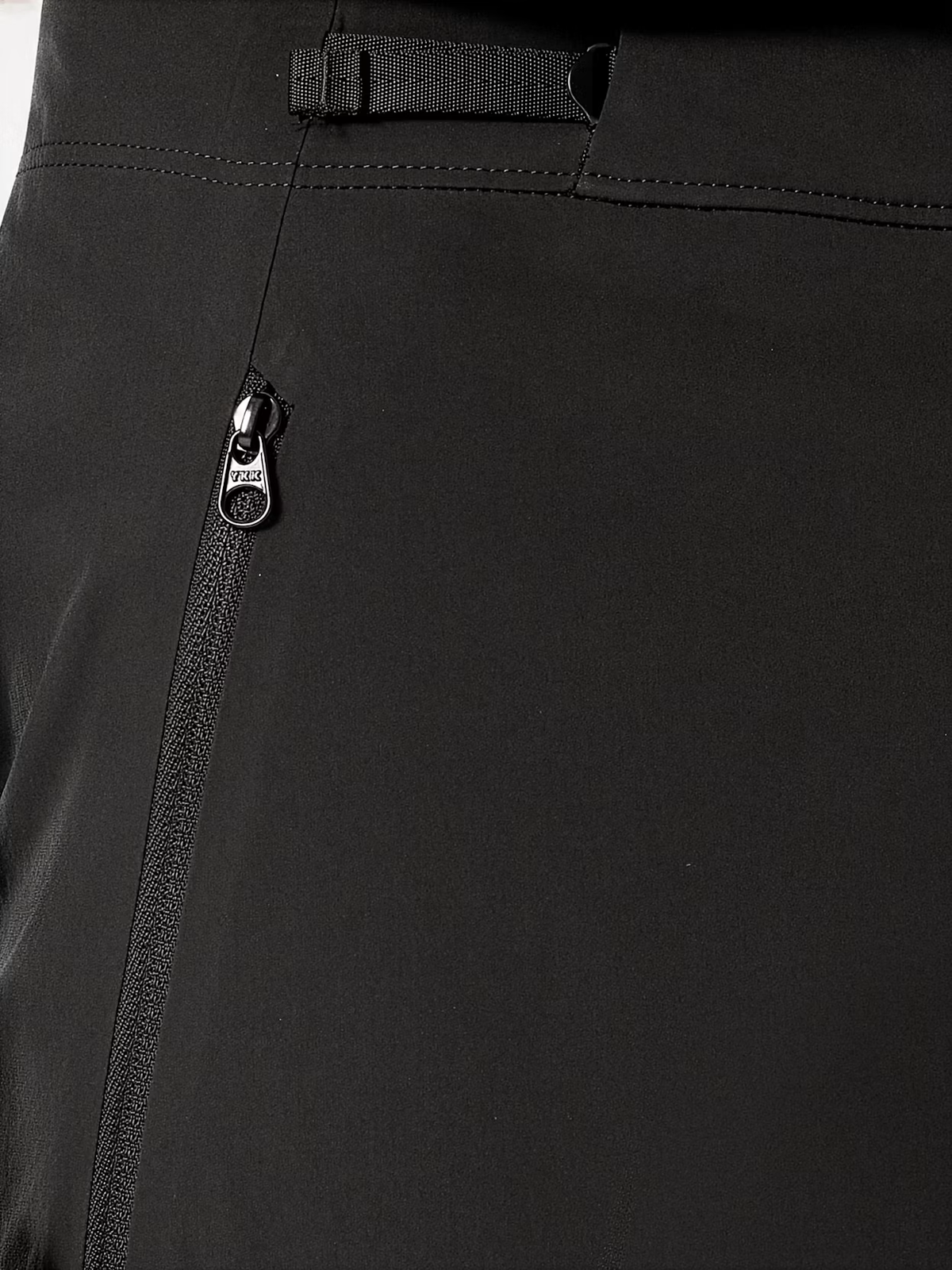 Close-up of black pants showing a zippered pocket with a silver zipper pull and belt loops at the waistband. - Arc'teryx Gamma SL Pants (Women's) - Black